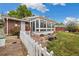 A brick home showcasing a spacious sunroom overlooking a landscaped backyard at 8137 Vanguard Dr, Denver, CO 80221