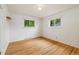 Bright bedroom featuring hardwood floors and natural light from two windows at 8137 Vanguard Dr, Denver, CO 80221