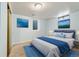 Basement bedroom with a large bed, blue accents, and natural light from a window well at 8137 Vanguard Dr, Denver, CO 80221