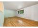 The light-filled bedroom featuring gleaming hardwood floors and neutral walls at 8137 Vanguard Dr, Denver, CO 80221