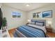 Comfortable bedroom features two bright windows and neutral colors with splashes of blue accents at 8137 Vanguard Dr, Denver, CO 80221
