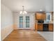 Bright dining area with hardwood floors and French doors to outdoor deck, adjacent to kitchen at 8137 Vanguard Dr, Denver, CO 80221
