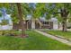 Charming brick home featuring a well-manicured lawn and inviting walkway to the front door at 8137 Vanguard Dr, Denver, CO 80221