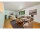 Staged living room featuring hardwood floors, modern furniture, and natural light at 8137 Vanguard Dr, Denver, CO 80221