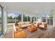 Bright sunroom with ample natural light, wood-look floors, and comfortable wicker furniture at 8137 Vanguard Dr, Denver, CO 80221