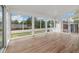 Bright sunroom with hardwood floors and numerous windows offering views of the backyard at 8137 Vanguard Dr, Denver, CO 80221