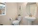 Well-lit half-bathroom features a pedestal sink, modern fixtures, and a window view at 524 E Hinsdale Ave, Littleton, CO 80122