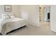 Modern bedroom featuring a comfortable bed, neutral carpet, and nearby access to the laundry room at 524 E Hinsdale Ave, Littleton, CO 80122