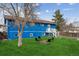 Spacious backyard featuring a classic blue home, a fire pit, and a welcoming outdoor space at 714 S Tabor St, Elizabeth, CO 80107
