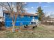 Spacious backyard featuring a classic blue home, a fire pit, and a welcoming outdoor space at 714 S Tabor St, Elizabeth, CO 80107