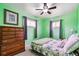 Cozy bedroom featuring light green walls, a comfortable bed, and a dresser at 714 S Tabor St, Elizabeth, CO 80107