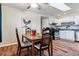 The dining room features a wood table, bright flowers and a view of the kitchen with white cabinetry at 714 S Tabor St, Elizabeth, CO 80107