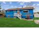 Charming blue two-story home with brown roof, white trim and fresh grass and welcoming front porch at 714 S Tabor St, Elizabeth, CO 80107