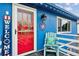 Charming blue home with a welcoming red door and a cozy, decorated front porch with light blue chair at 714 S Tabor St, Elizabeth, CO 80107