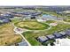 Aerial view of community with large green space, playground, and a lake, surrounded by modern homes at 502 Green Mountain Dr, Erie, CO 80516