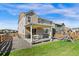 The fenced-in backyard has a covered patio, gravel area and a playset on the lawn at 502 Green Mountain Dr, Erie, CO 80516