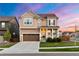 Beautiful two-story home with inviting front porch, lush lawn, and a colorful sunset backdrop at 502 Green Mountain Dr, Erie, CO 80516