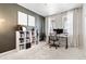 Bright home office featuring a large window, white desk, modern chair, and white bookcase at 502 Green Mountain Dr, Erie, CO 80516