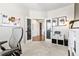 A home office with french doors, neutral carpet, a grey chair, and a small storage unit at 502 Green Mountain Dr, Erie, CO 80516