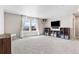Spacious living room with large windows, plush carpeting, and media console, perfect for entertaining at 502 Green Mountain Dr, Erie, CO 80516