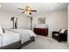 Comfortable main bedroom with neutral walls, a ceiling fan, wood dresser, and a cozy reading chair at 502 Green Mountain Dr, Erie, CO 80516