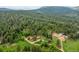 Expansive aerial view of multiple homes nestled among lush green trees and rolling hills at 245 N County Highway 67, Sedalia, CO 80135