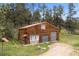 Large barn with brown wood siding, stone accents, and a red metal roof at 245 N County Highway 67, Sedalia, CO 80135