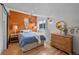 Bright bedroom with orange accent wall, pendant lighting, and hardwood flooring, creating a cozy retreat at 245 N County Highway 67, Sedalia, CO 80135