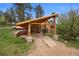 Rustic carport featuring log beams and stone pillar bases, leading to the home at 245 N County Highway 67, Sedalia, CO 80135