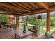 Relaxing covered deck with a wood ceiling, dining set, comfortable seating and a forest view at 245 N County Highway 67, Sedalia, CO 80135