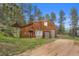 Spacious two-car garage with wood siding and stone accents, complemented by a green lawn at 245 N County Highway 67, Sedalia, CO 80135