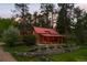Picturesque exterior featuring a red roof, wood siding and a cozy porch with furniture at 245 N County Highway 67, Sedalia, CO 80135