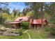 Scenic exterior view of log cabin home with a red roof and stone chimney at 245 N County Highway 67, Sedalia, CO 80135