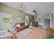 Spacious living room featuring hardwood floors, a comfortable leather sofa, and a modern ceiling fan at 245 N County Highway 67, Sedalia, CO 80135