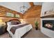 Cozy bedroom features log walls, a fireplace, natural light and a neutral color palette at 245 N County Highway 67, Sedalia, CO 80135