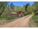 Two wooden outbuildings surrounded by a chain link fence along a dirt path at 245 N County Highway 67, Sedalia, CO 80135