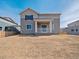 Back of a grey two-story house featuring a small patio and an unfinished yard at 10145 Quentin Ct, Commerce City, CO 80022