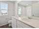 This bathroom features a window over the toilet and a wide mirror reflecting the shower at 10145 Quentin Ct, Commerce City, CO 80022