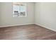 Bright bedroom with wood-look flooring, neutral paint, a large window, and views of the neighborhood at 10145 Quentin Ct, Commerce City, CO 80022