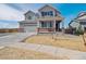Charming two-story home with a covered front porch, a two-car garage, and professionally landscaped front yard at 10145 Quentin Ct, Commerce City, CO 80022