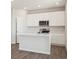 Modern kitchen with white cabinets, stainless steel appliances, and an island, offering a clean and efficient design at 10145 Quentin Ct, Commerce City, CO 80022
