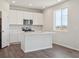 Modern kitchen with white cabinets, stainless steel appliances, and an island, illuminated by a sunny window at 10145 Quentin Ct, Commerce City, CO 80022