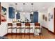 Modern kitchen with breakfast bar, white countertops, stylish pendant lighting, and navy blue cabinets at 3044 W 37Th Ave, Denver, CO 80211