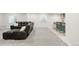 Finished basement with a large sectional sofa and a bar area with stools and cabinets at 12563 Grape St, Thornton, CO 80241