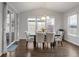 Bright dining room features modern chandelier, hardwood floors, and multiple large windows at 12563 Grape St, Thornton, CO 80241