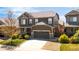 Charming two-story home features a well-maintained lawn and a two-car garage, complemented by a stone-accented facade at 12563 Grape St, Thornton, CO 80241