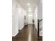 Inviting entry hall with gleaming wood floors, convenient coat rack, and staircase with wood railing at 12563 Grape St, Thornton, CO 80241