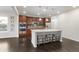 This kitchen features a large island with seating, stainless appliances, and dark wood floors at 12563 Grape St, Thornton, CO 80241