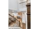 Open-concept living area with kitchen, dining, and lounge areas visible from the staircase at 12563 Grape St, Thornton, CO 80241