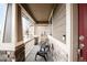 Inviting covered front porch showcases stone pillars, white railing, and cozy seating for relaxing outdoors at 12563 Grape St, Thornton, CO 80241